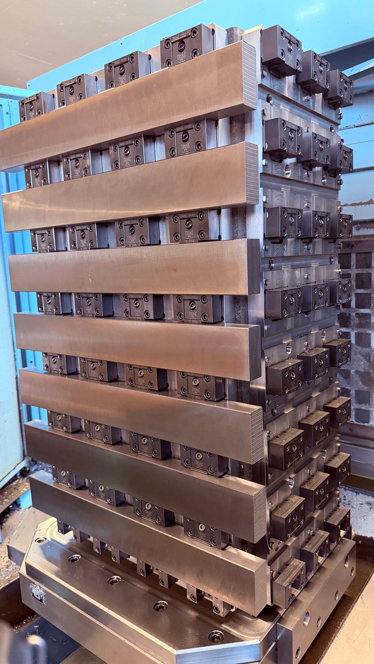Tombstone fixture loaded with rows of metal bars on multiple faces